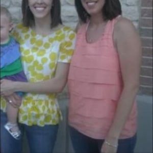 Sleeveless tiered top. Soft orange/coral.